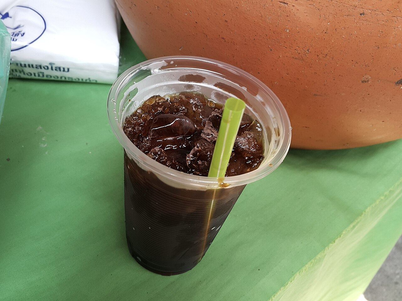Oliang, traditional Thai iced coffee, in a takeaway cup at a market in Ayutthaya, Thailand