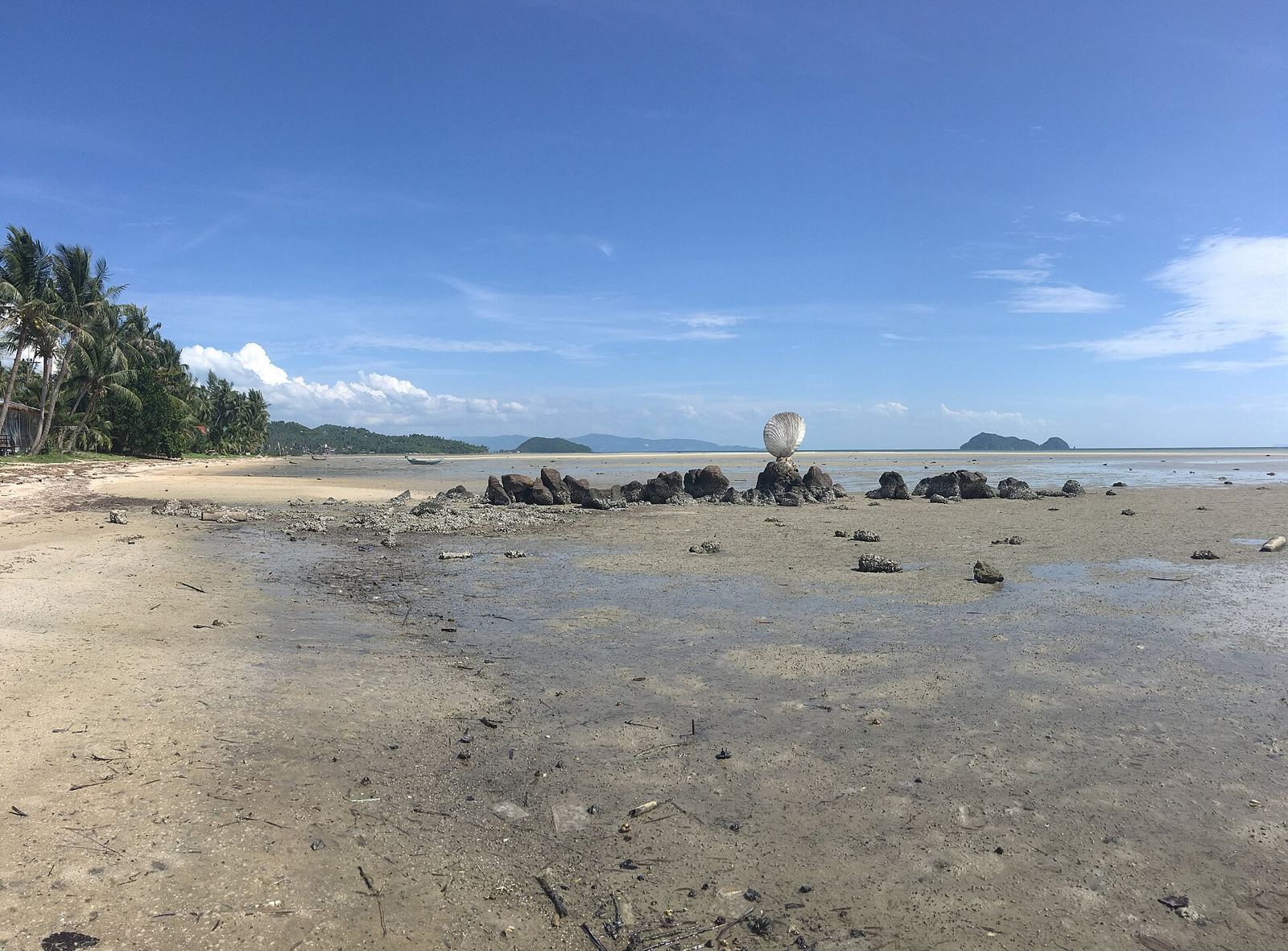 หาดหินกอง เกาะพะงัน ตอนน้ำลง ผืนทรายเปียกและโขดหินทอดยาวออกไปทางทะเล